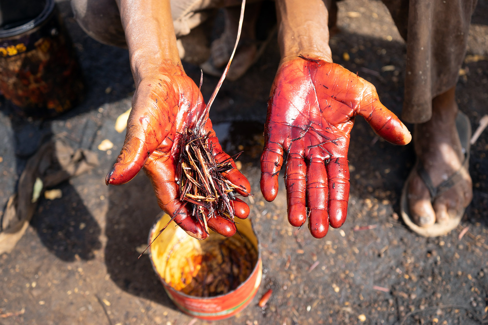 Rote Farbe auf Händen zum Färben von Leder in Gahan