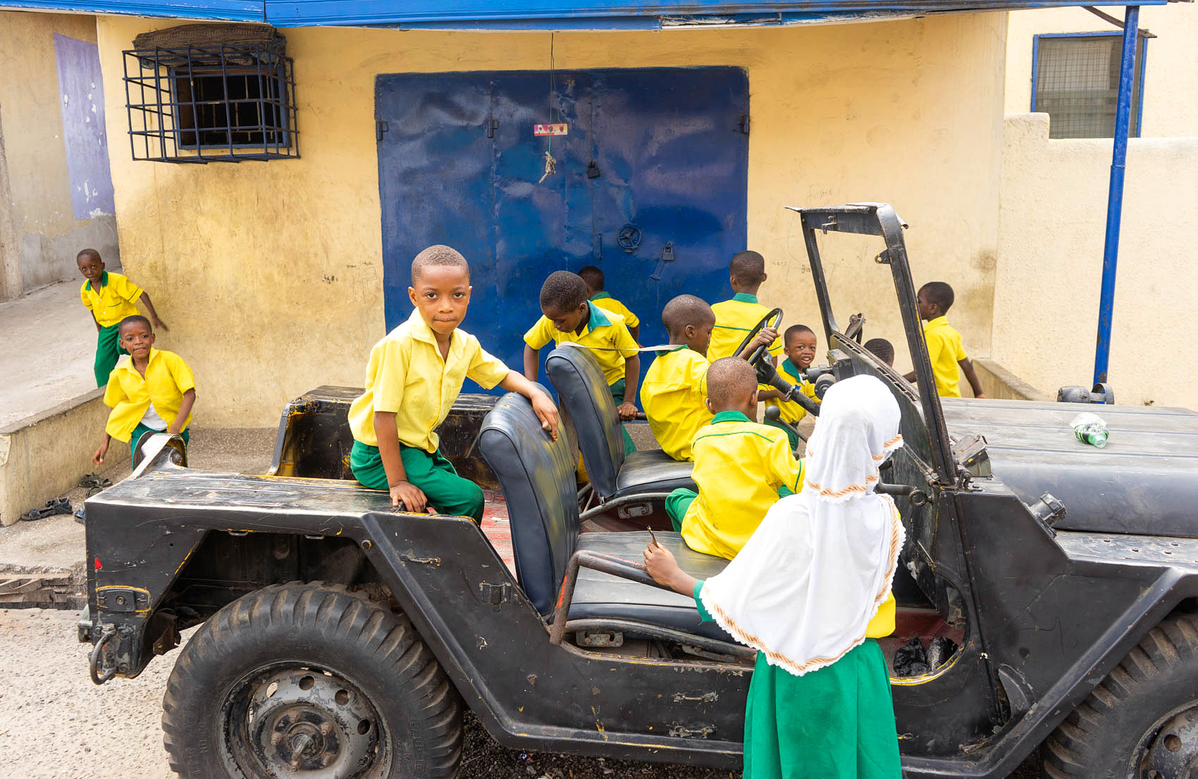 Kinder spielen mit altem Jeep in Afrika