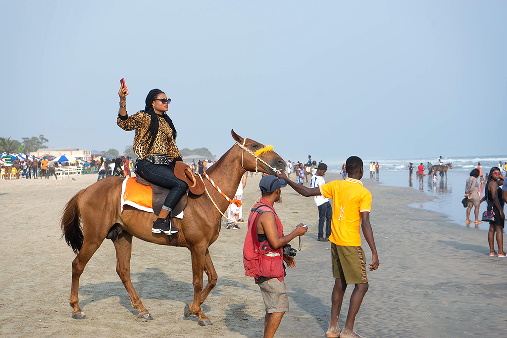 Selfie Queen auf eine Pferd am Strand in Accra