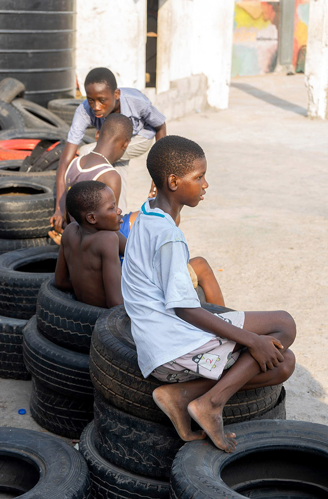 Kinder in Accra sitzen auf alten Reifen